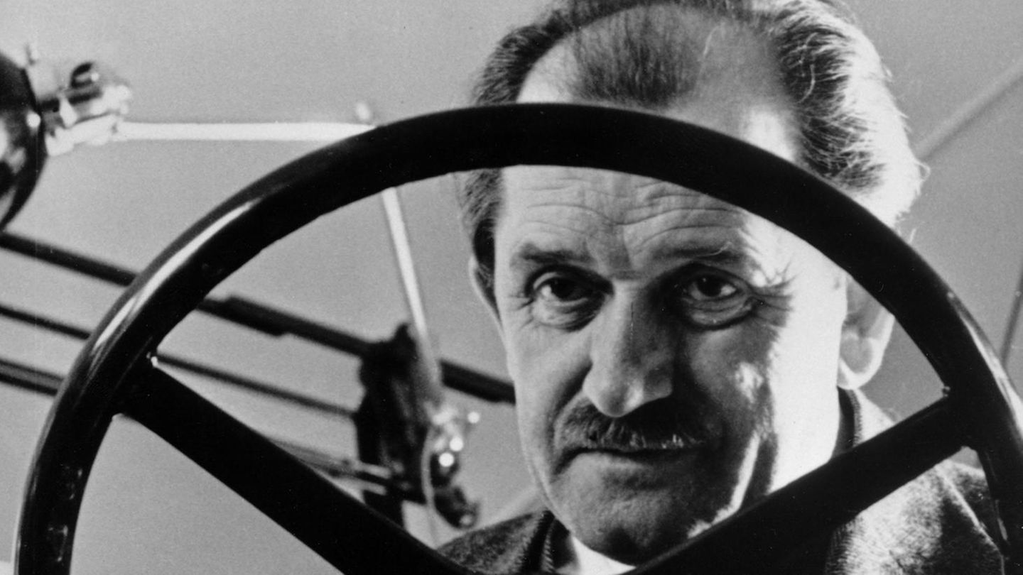Ferdinand Porsche hinter einem Lenkrad in der Werkstatt