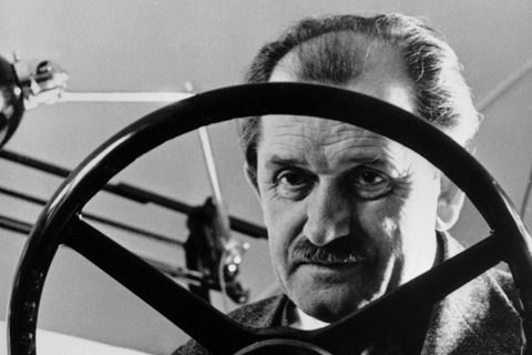 Ferdinand Porsche hinter einem Lenkrad in der Werkstatt