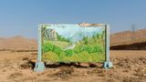Image Name: Chahar Mahal and Bakhtiari Province – Kurd City – 2021  Photographer Name: Majid Hojjati  Year: 2022  Image Description: A painting of lush nature, with the clean climate of Chahar Mahal and Bakhtiari province’s past,  is located in the dry desert of this province. The sign reads: ‘I must remember not to do anything that is against the law of the Earth’.  Series Name: The Earth Belongings  Series Description: Life has meaning in human beliefs with its symbols. Mountains, forests, plains, free and beautiful creatures, and clear blue skies are all creations that will come to mind when we hear the word ‘life’. Where it is free from the fence of man, and there is no trace of human presence in it, it is ‘nature’. Where humans stepped in without understanding and respecting the spirit of nature, they endangered the existence of other beings. And then from this soil, nothing but a lifeless body will remain. The mountains will forget the flight of the eagles, and the noble howls of the horses will not be heard in the plains; and even the lion, that king of the forest, will be only a name in the books. These elements belong to the planet and are inseparable from it, without them what is left is a cold, lost and distorted image that no longer resembles anything. Maybe it's time to weigh what we have taken from nature and what we have given it and measure what we have done with the universe.