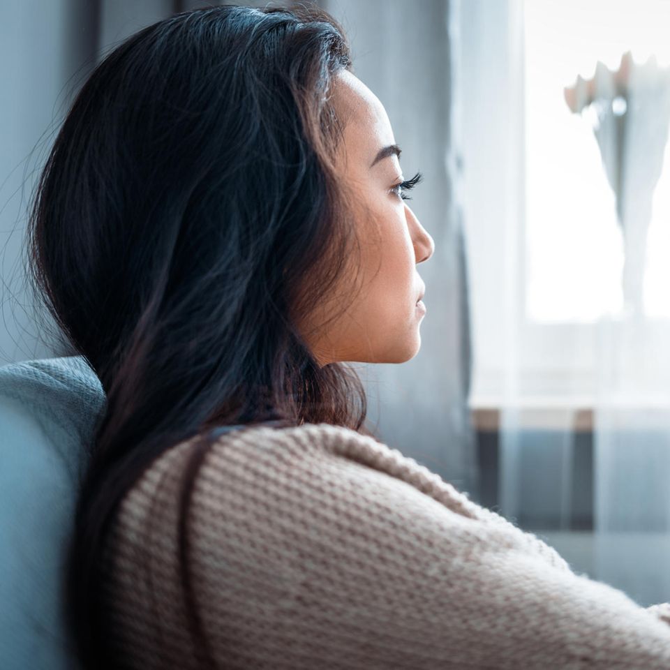 Mental erschöpfte Frau sitzt auf der Couch