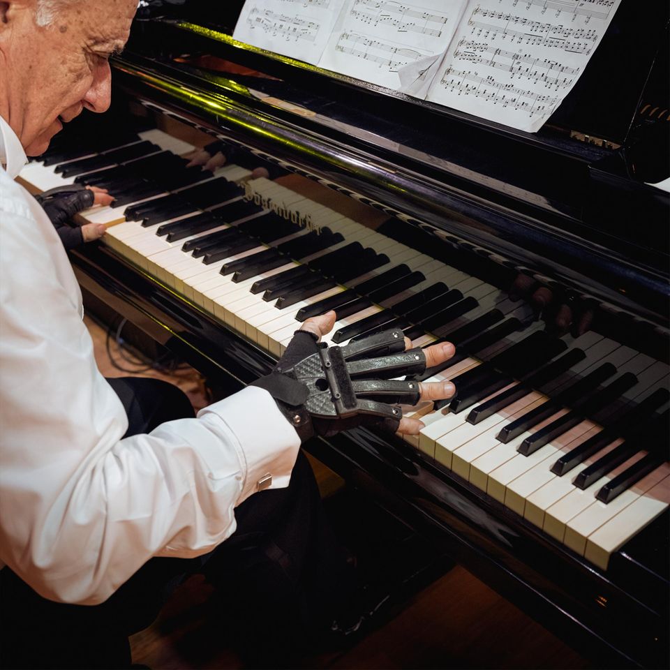 Endlich kann Joao Carlos Martins wieder Klavier spielen – dank spezieller Handschuhe, die ihm helfen, seine Finger zu strecken