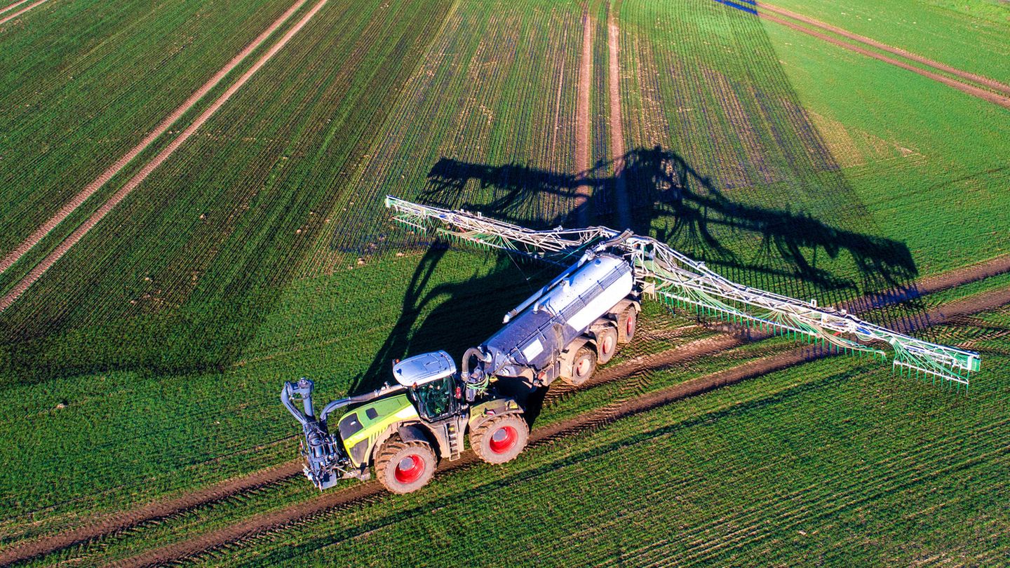 Trecker bringt Gülle auf einer landwirtschaftlichen Fläche aus