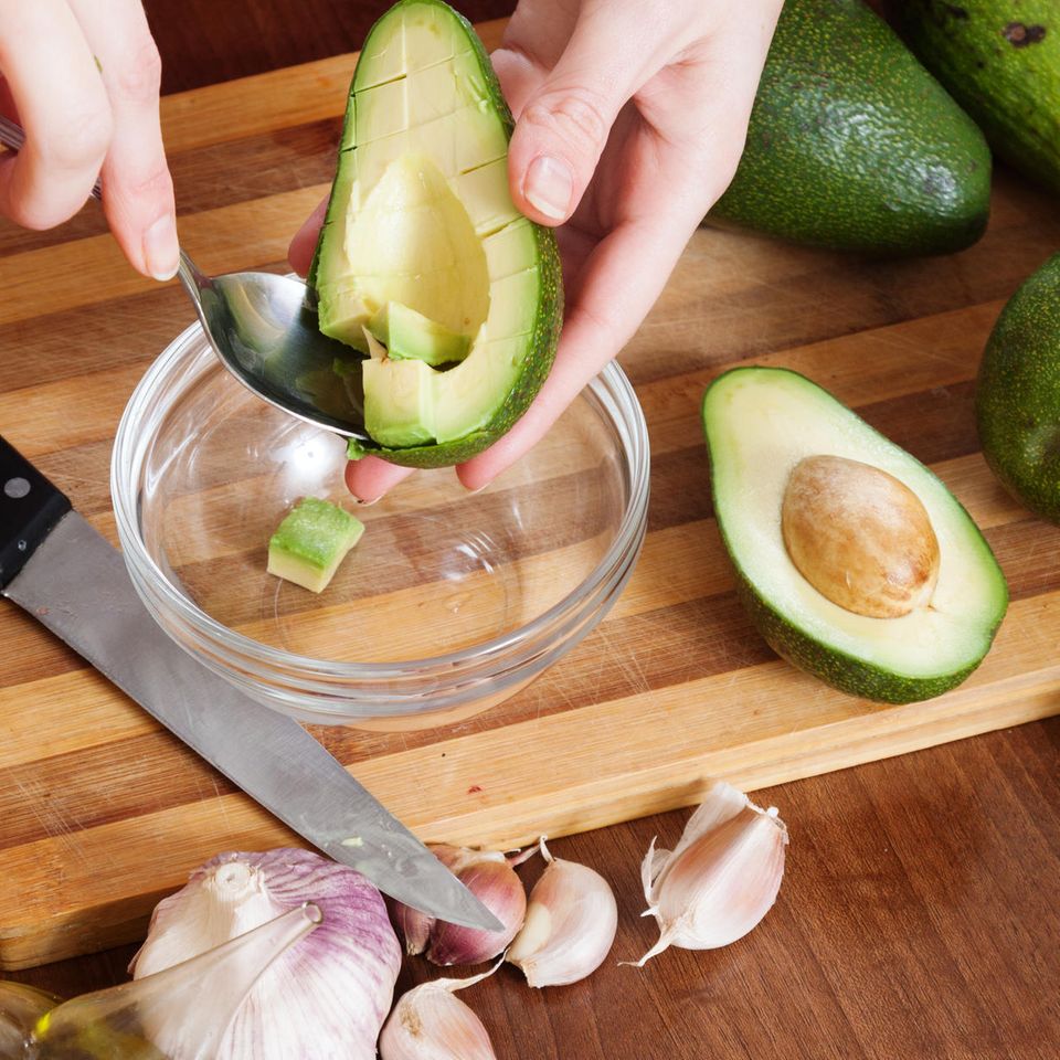 Zubereitung einer Avocado auf einem Holzbrett