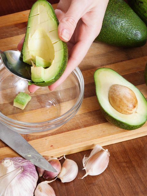 Zubereitung einer Avocado auf einem Holzbrett