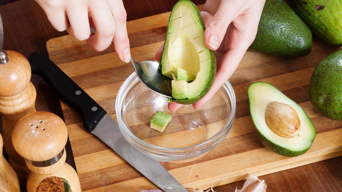 Zubereitung einer Avocado auf einem Holzbrett