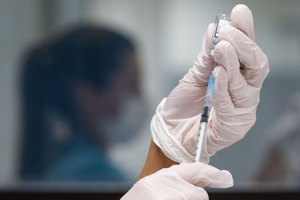 Eine Frau zieht eine Dosis des Impfstoffes von Biontech/Pfizer für eine Corona-Impfung auf