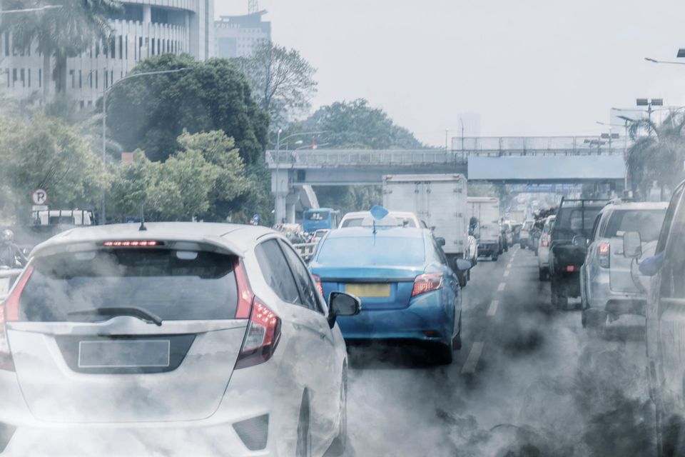 Luftverschmutzung durch Stau auf einer Straße  mitten in der Stadt
