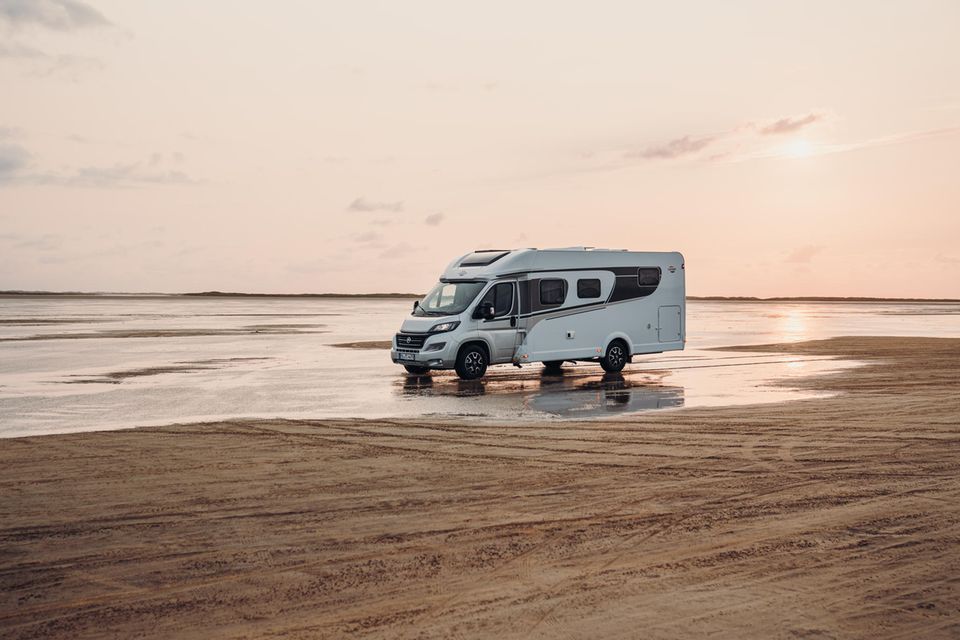 Camper steht auf einem weitläufigen Strand