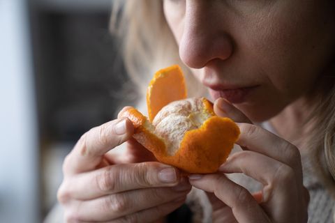 Eine Frau riecht an einer Mandarine