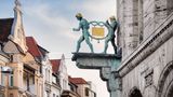 Bahlsens Keks-Fabrik ist nicht nur für Kekse berühmt, sondern auch für die Synergie von Kunst und Kommerz. Modernste Schriften und Formen förderten das Marketing. Auch das Wahrzeichen am Firmensitz in Hannover ist ausgefallen. Zwei nackte Männer tragen den berühmten goldenen Keks in der Trageform einer Brezel. Einst wurde er spektakulär entwendet, jetzt ist er wieder da