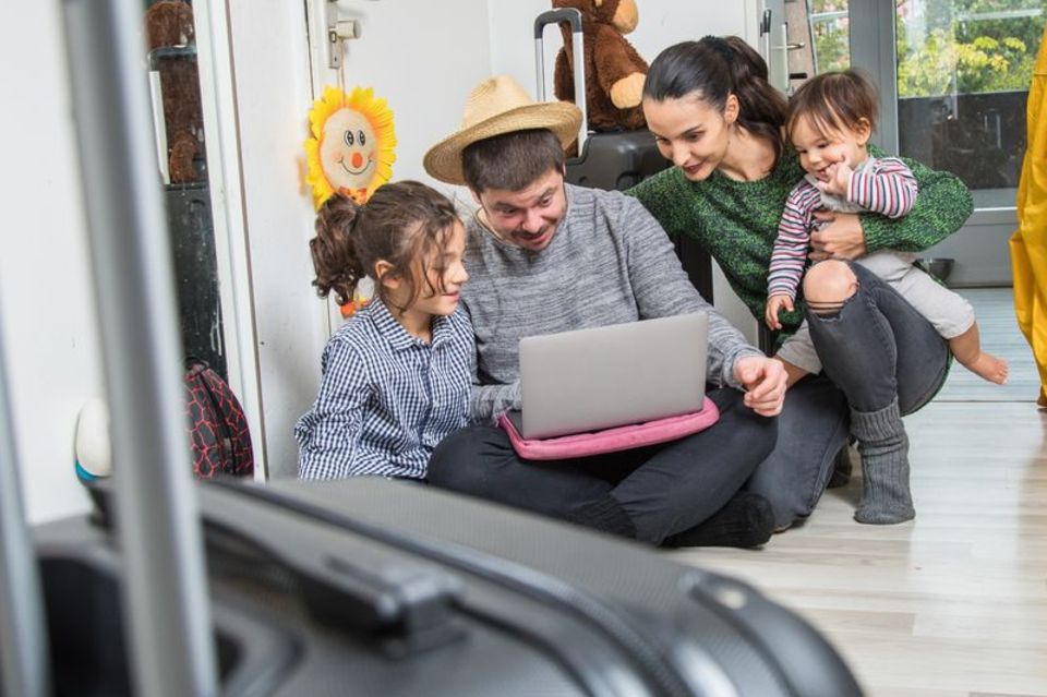 Familie mit Kindern plant den Urlaub am Laptop