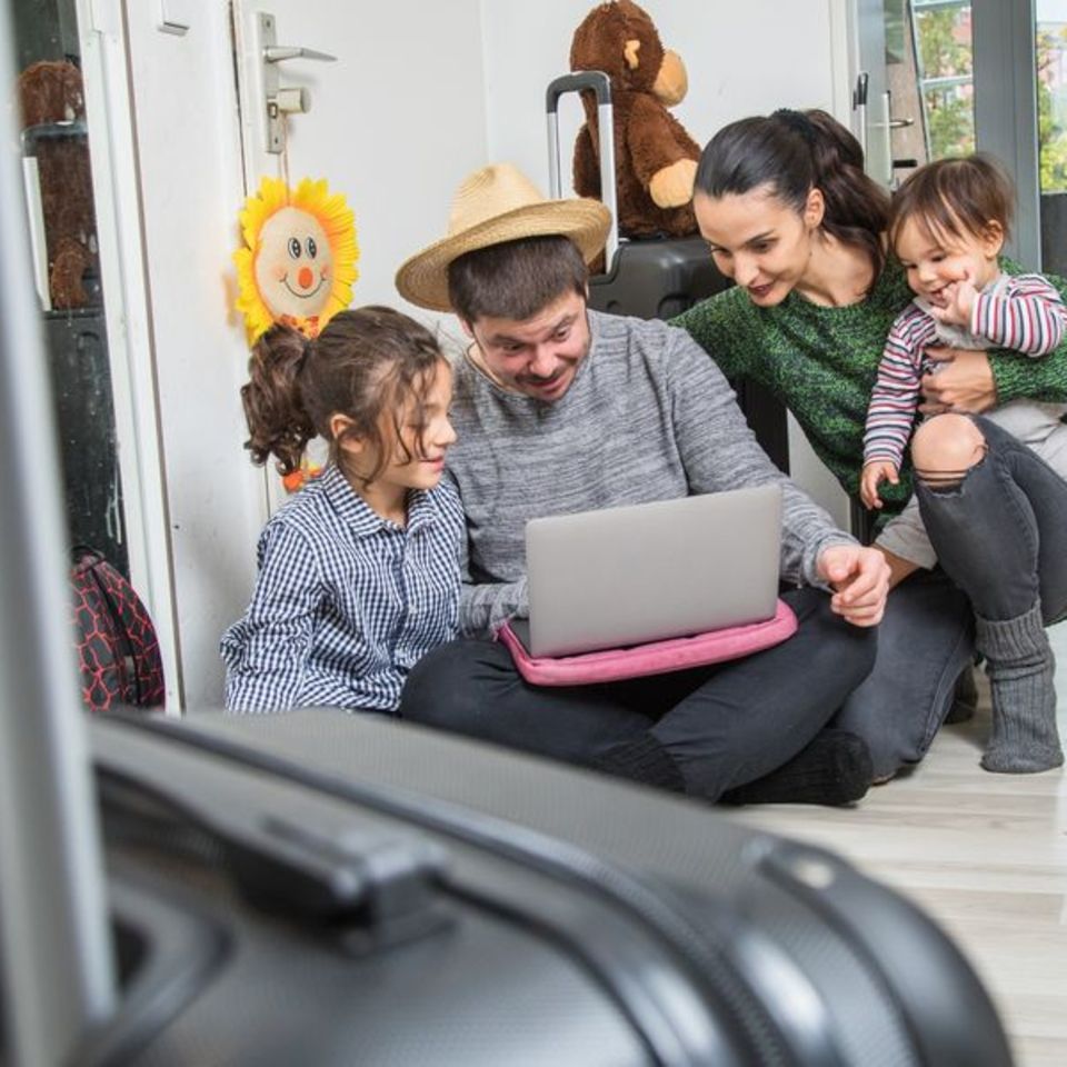 Familie mit Kindern plant den Urlaub am Laptop
