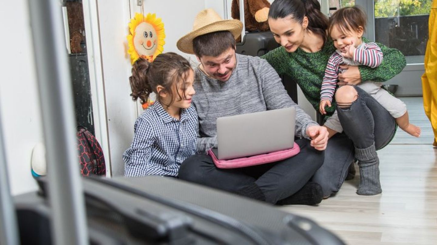Familie mit Kindern plant den Urlaub am Laptop