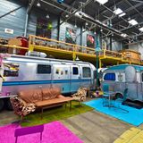 Blick auf den Indoor-Campingplatz. Zwei Silberne Campingwagen in bunter Kulisse