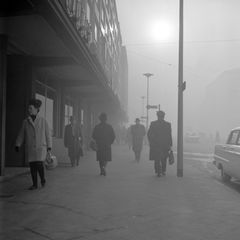Personen laufen auf einer Straße in Gelsenkirchen durch Smog