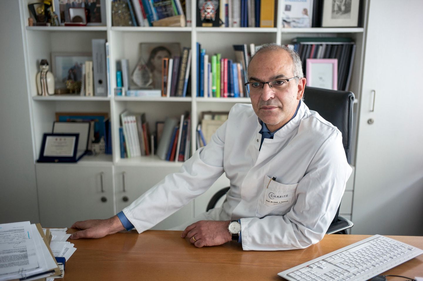 Der Gynäkologe Prof. Jalid Sehouli sitzt an seinem Schreibtisch an der Frauenklinik der Charité - Universitätsmedizin Berlin