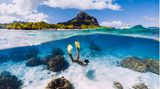 Freediverin mit gelben Schwimmflossen im Wasser vor Mauritius