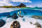 Freediverin mit gelben Schwimmflossen im Wasser vor Mauritius