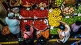 Blick von oben auf einen Obst- und Gemüsestand mit Tomaten, Zitronen und Möhren