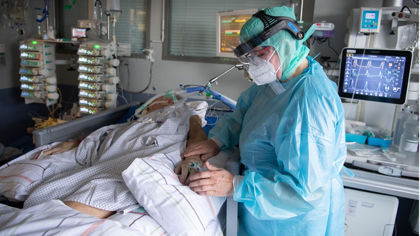 Eine Intensiv-Pflegerin versorgt einen schwer an Corona erkrankten Patienten auf der Intensivstation des Klinikums in Fulda
