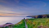 Mann auf dem Pembrokeshire Coast Path bei Sonnenuntergang