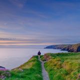 Mann auf dem Pembrokeshire Coast Path bei Sonnenuntergang