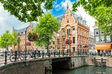 Kanal mit alten Häusern und einer Brücke in Amsterdam