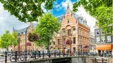Kanal mit alten Häusern und einer Brücke in Amsterdam