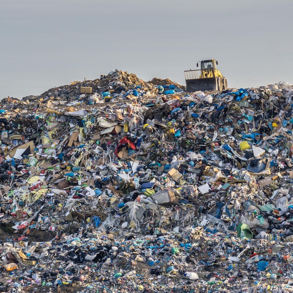 Bagger auf einer riesigen Deponie mit Plastikmüll
