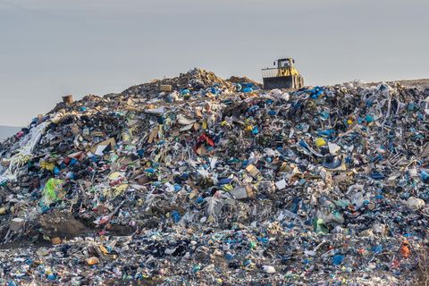 Bagger auf einer riesigen Deponie mit Plastikmüll