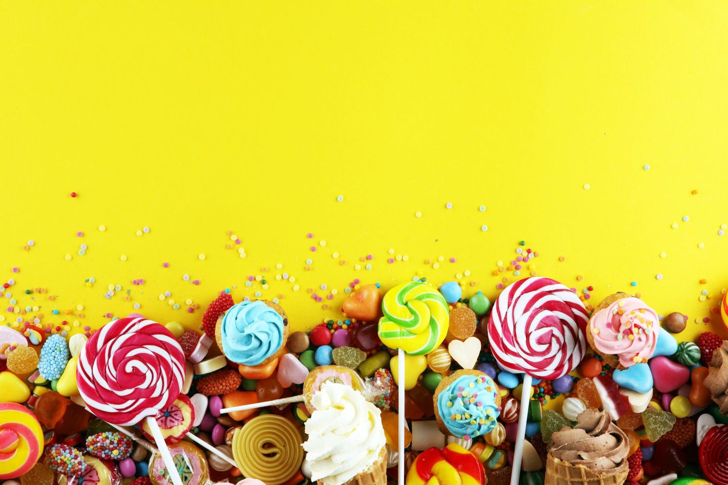 Diverse Süßigkeiten auf gelbem Hintergrund