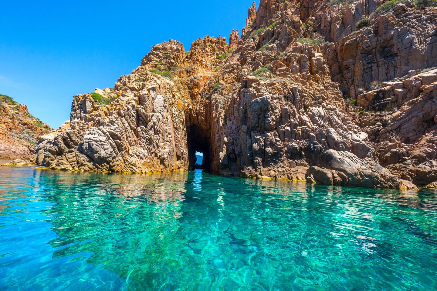 Calanche - Roter Porphyr und Meer Rötlich schimmerndes Felsentor im türkisen Meer