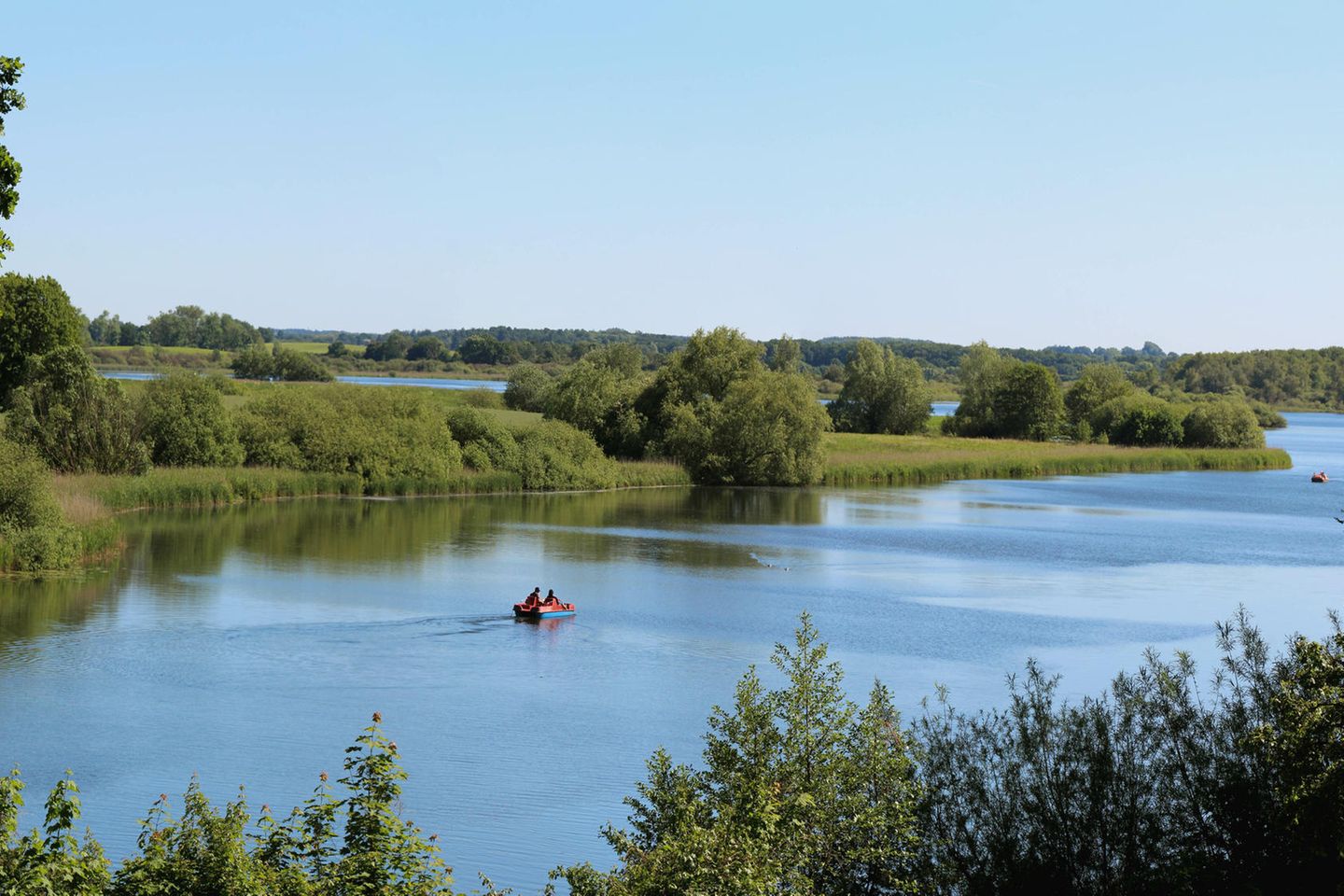 Auf der Schwentine paddeln Menschen in einem Boot