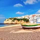 Im Vordergrund ist ein Boot zu sehen, im Hintergrund Häuser auf einer Steilküste