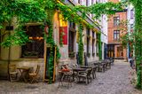 Alte Straße mit Restauranttischen in Antwerpen, Belgien