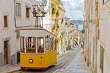 Gelbe Straßenbahn in einer Straße von Lissabon