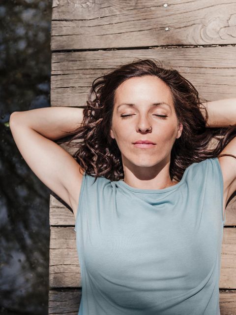 Frau liegt entspannt auf einem Steg