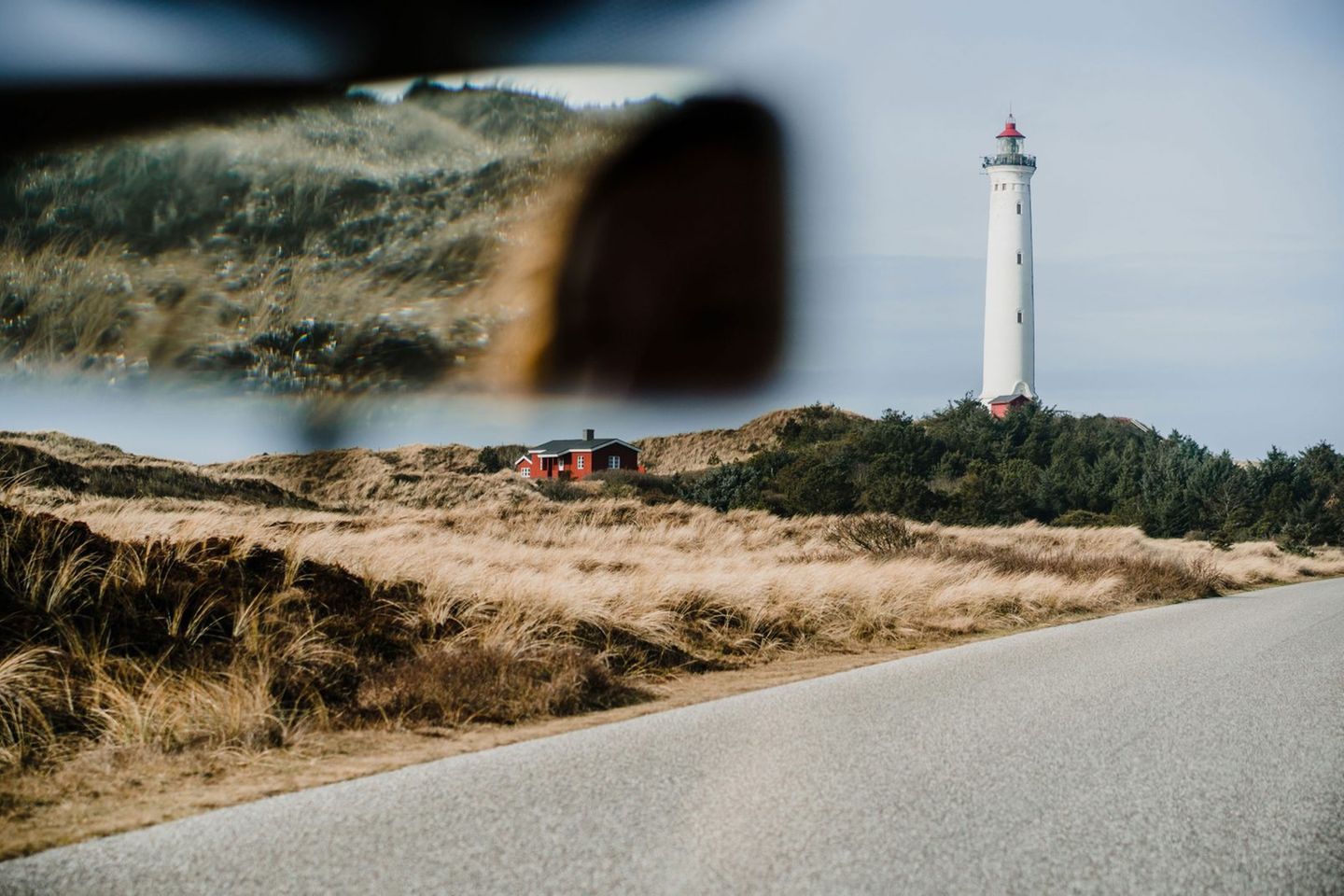 Blick aus der Frontscheibe eines Autos auf den Leuchtturm Lyngvig