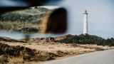 Blick aus der Frontscheibe eines Autos auf den Leuchtturm Lyngvig