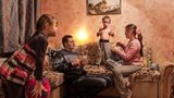 Eltern sind mit ihren zwei Kindern in einem Wohnzimmer