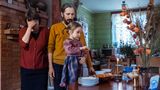 Mutter und Vater stehen mit der Tochter in der Küche vor einem Tisch, auf dem Essen steht