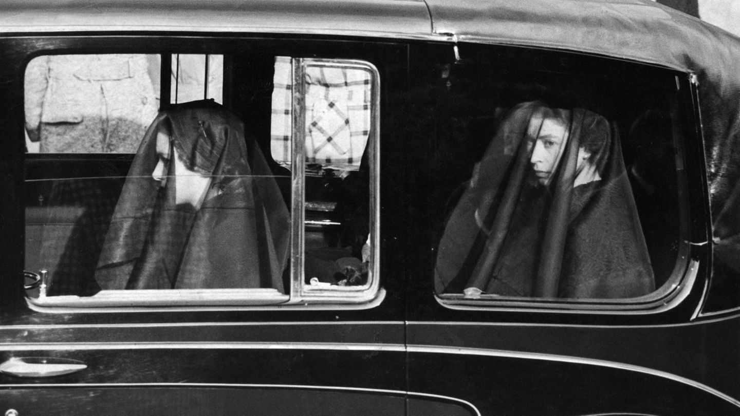 IN TRAUER Elisabeth (r.) und Margaret am 11. Februar 1952 bei der Überführung ihres Vaters, der fünf Tage zuvor vermutlich an Lungenkrebs gestorben ist. Die Nachricht hat Elisabeth auf einer Reise in Kenia erreicht. Durch seinen Tod ist sie nun automatisch Königin