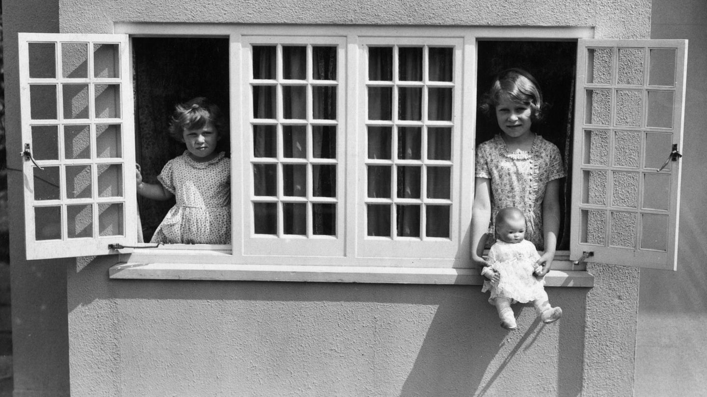 ZWEI SCHWESTERN Elisabeth und die vier Jahre jüngere Margaret werden von Privatlehrern unterrichtet und haben als Spielgefährtinnen vor allem einander. Hier posieren sie in einem Minicottage – einem Geschenk der Bevölkerung von Wales zu Elisabeths sechstem Geburtstag. Daheim haben die Geschwister ein ganzes Stockwerk für sich.