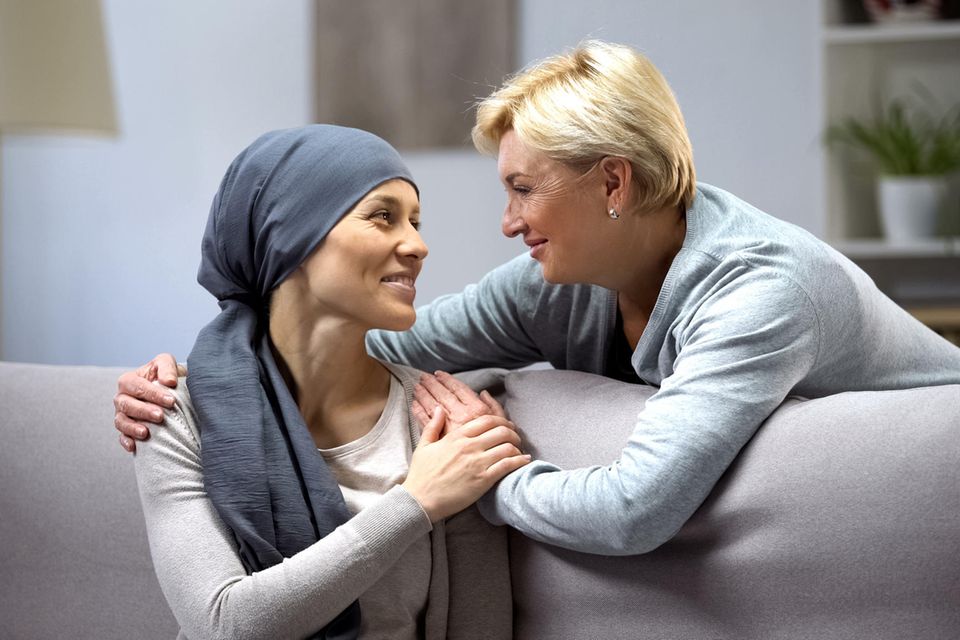 Zwei Frauen umarmen sich, die eine Frau hat Krebs
