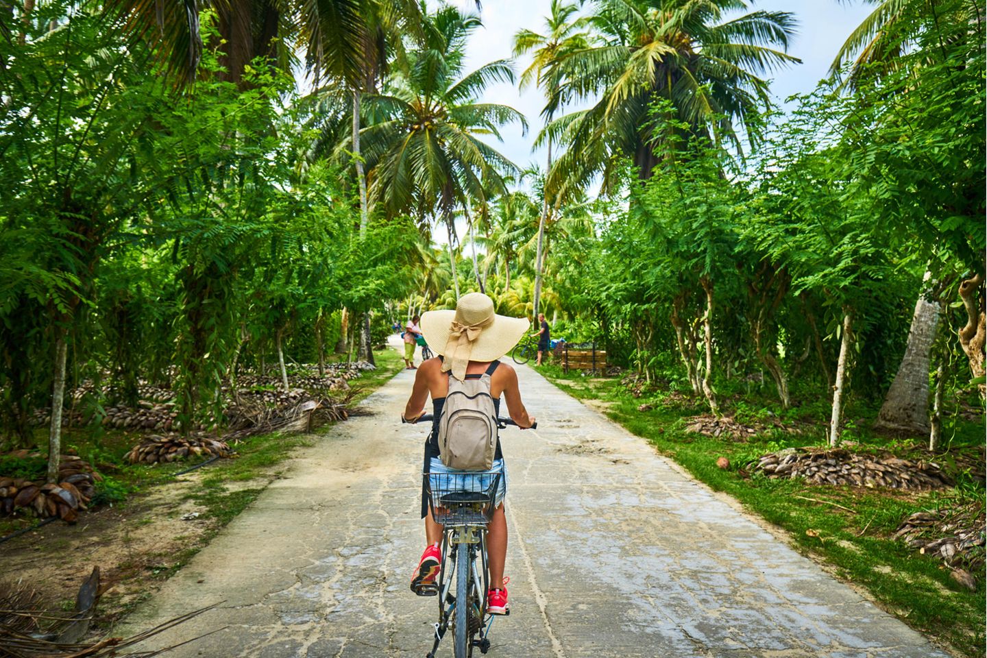 Mit dem Fahrrad über La Digue Frau fährt Rad auf den Seychellen