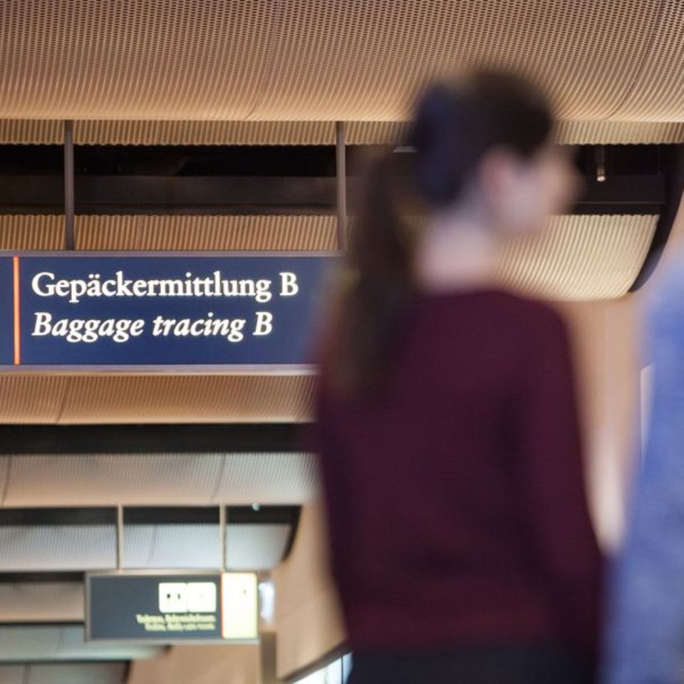 In Unschärfe ein Paar am Schalter der Gepäckermittlung