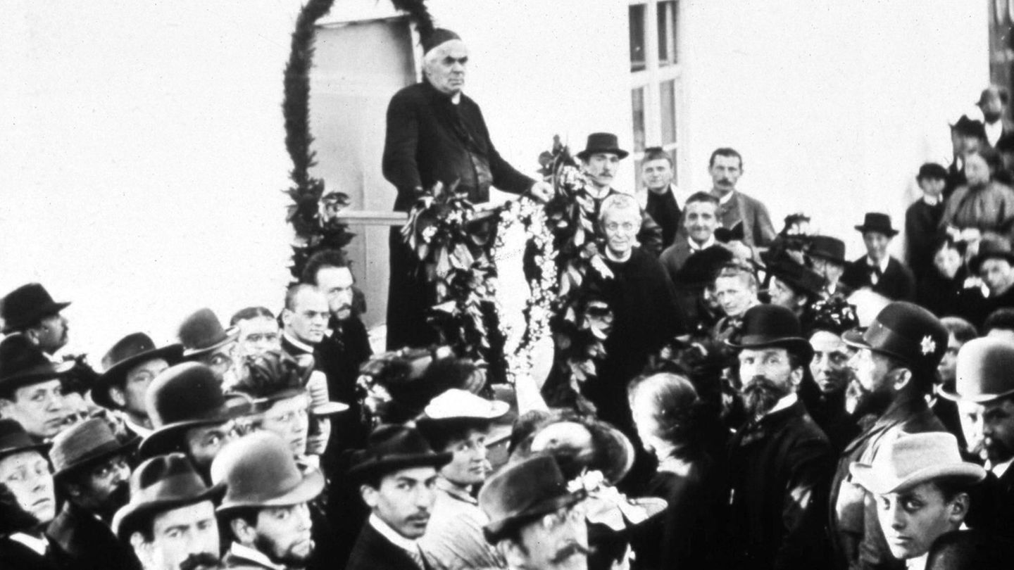 Umringt von Zuhörerinnen und Zuhörern: Kneipps Vorträge sind oft gut besucht – bis an sein Lebensende. Am 17. Juni 1897 stirbt der Wasserdoktor an einem Krebsgeschwür im Unterleib. Seine Ideen aber haben längst eine weltweite Gesundheitsbewegung hervorgebracht.