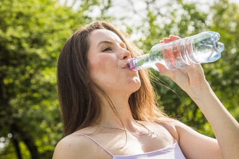Eine Frau trinkt Mineralwasser aus einer Flasche
