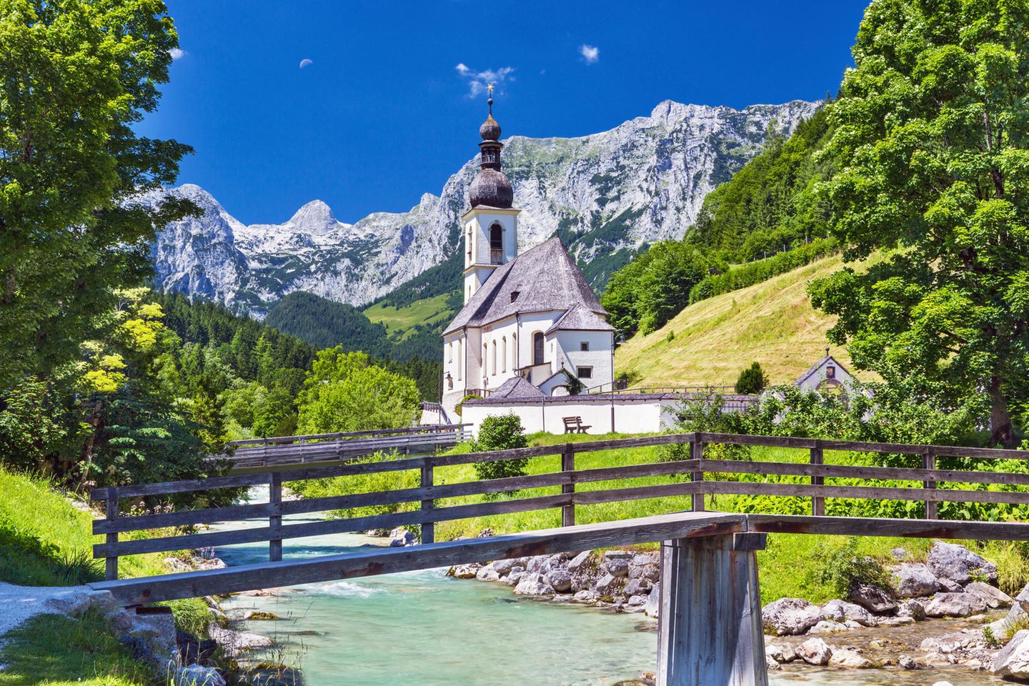 Pfarrkirche St. Sebastian: Göttliche Lage Die Pfarrkirche St. Sebastian mit Ramsauer Ache und Ertlsteg im Vordergrund sowie der Reiter Alpe im Hintergrund
