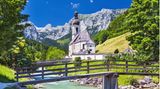 Die Pfarrkirche St. Sebastian mit Ramsauer Ache und Ertlsteg im Vordergrund sowie der Reiter Alpe im Hintergrund